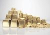 Gold bar and gold coin on white background.